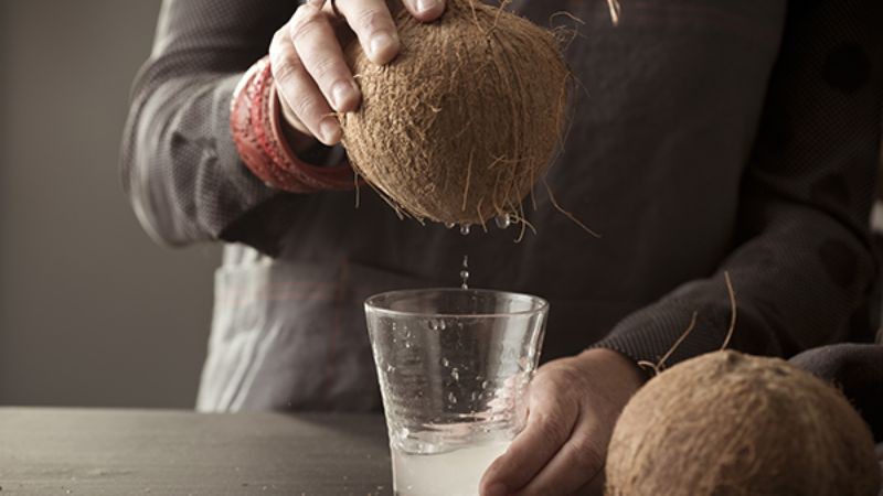 Úp ngược quả dừa vào ly để trút hết nước